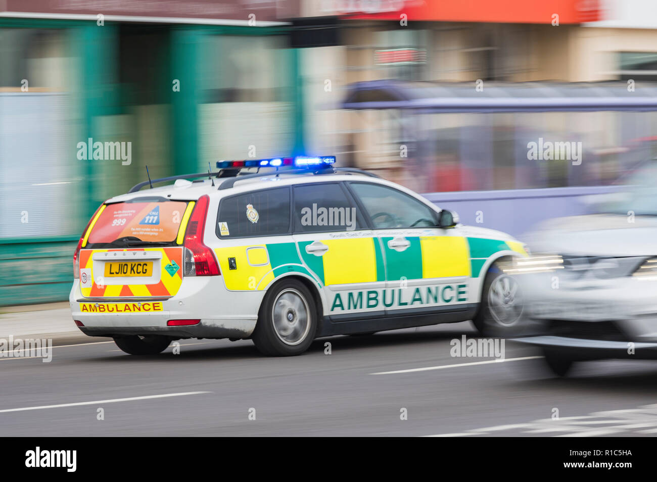 Ambulanza risposta veloce auto con luci blu lampeggiante sul modo per chiamata di emergenza nel West Sussex, Regno Unito. Motion Blur effetto. Foto Stock