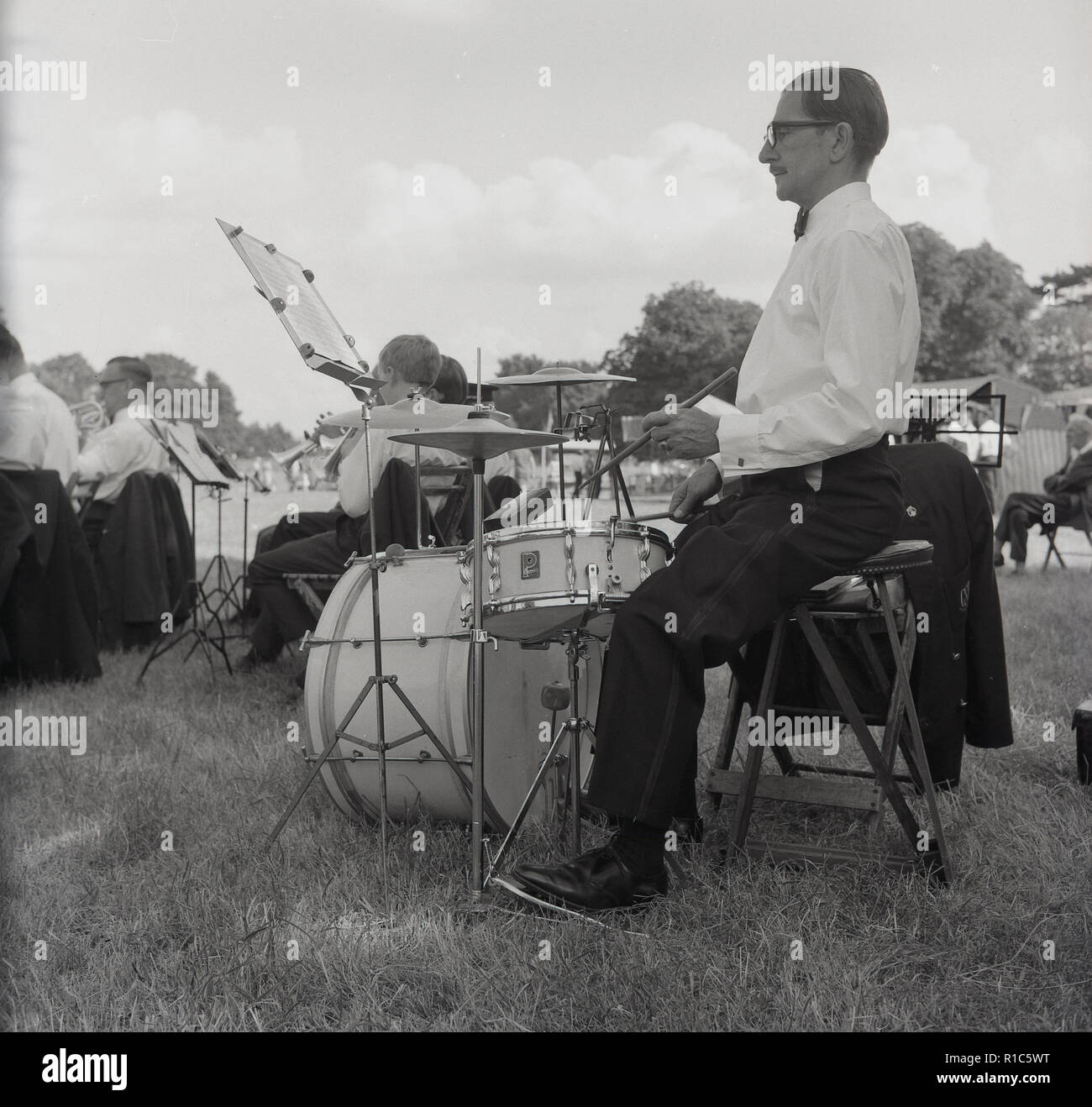 1967, Tring Performing Arts Festival, un maschio il batterista in una band che suona a caso al di fuori di un campo. Foto Stock