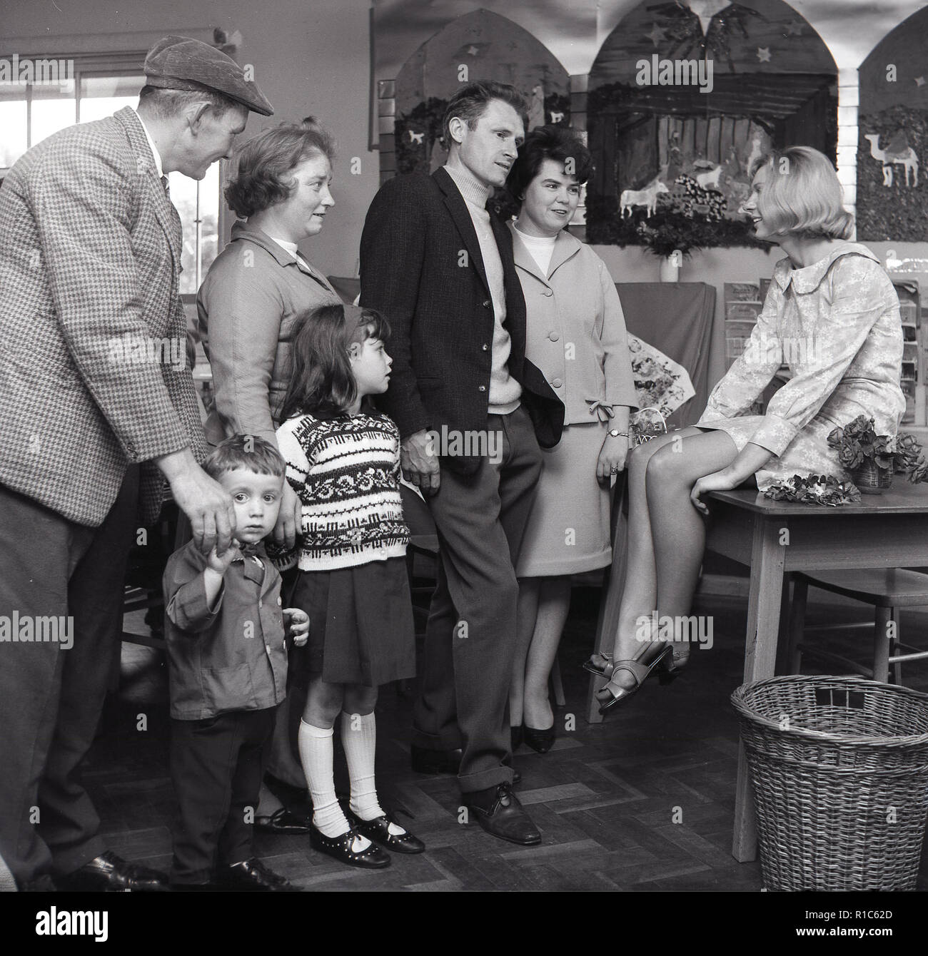 1967, scuola primaria, un bambino di genitori e nonni a parlare con un insegnante femminile in una classe che indossa un floreali mini abito, England Regno Unito. Foto Stock