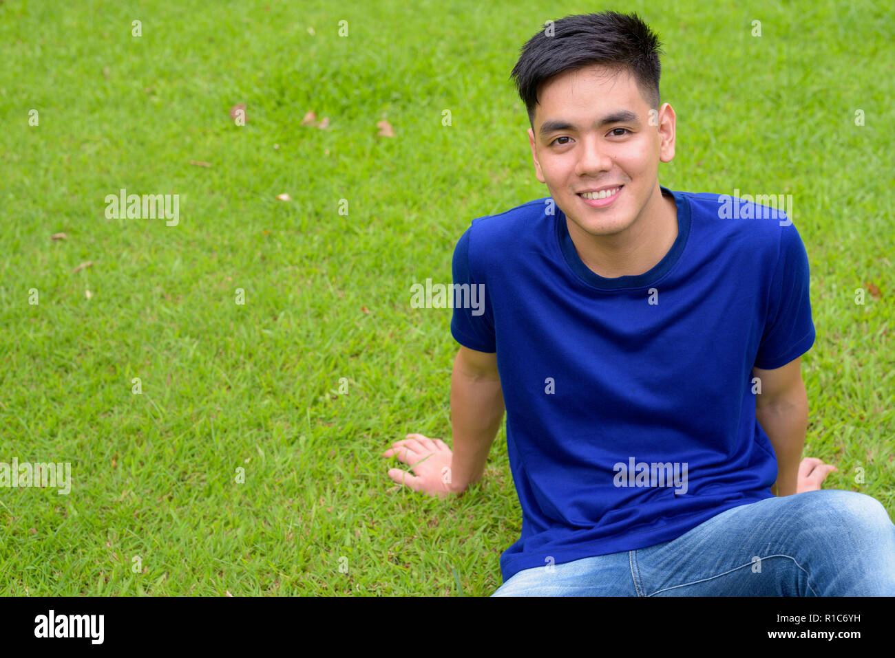 Bel giovane uomo asiatico di relax presso il parco Foto Stock