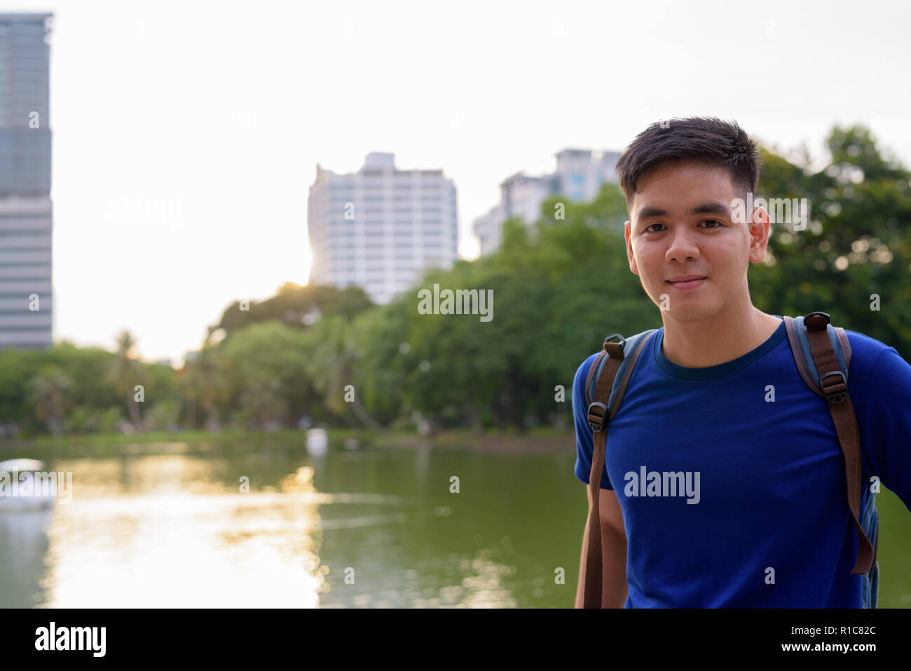 Giovani asiatici bello uomo turistica con uno zaino di relax presso la p Foto Stock