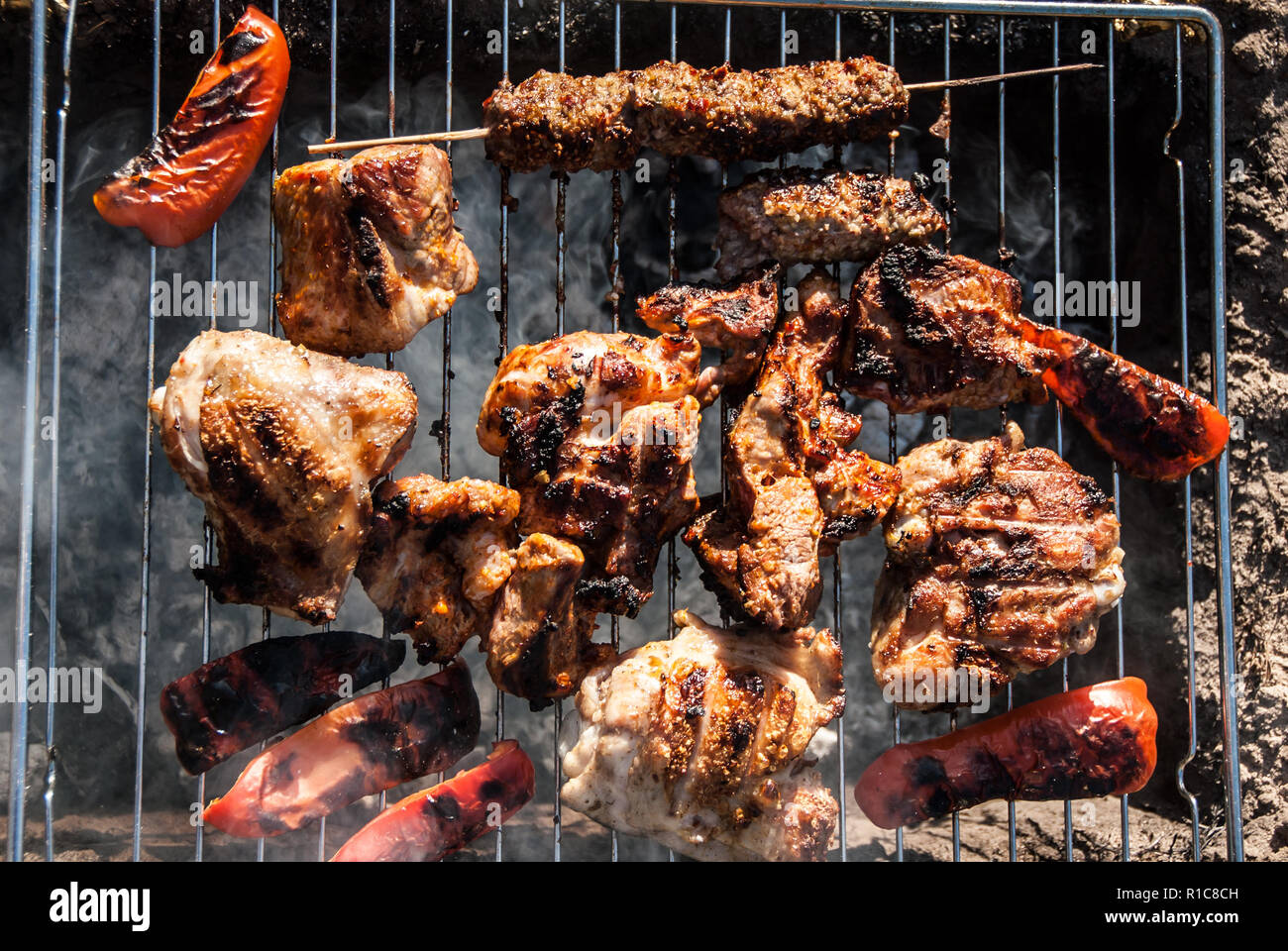 La carne e il peperone rosso shish spiedini di grigliare sulla griglia. Barbecue in tourist forest camp. Concetto - cibo sano. Foto Stock