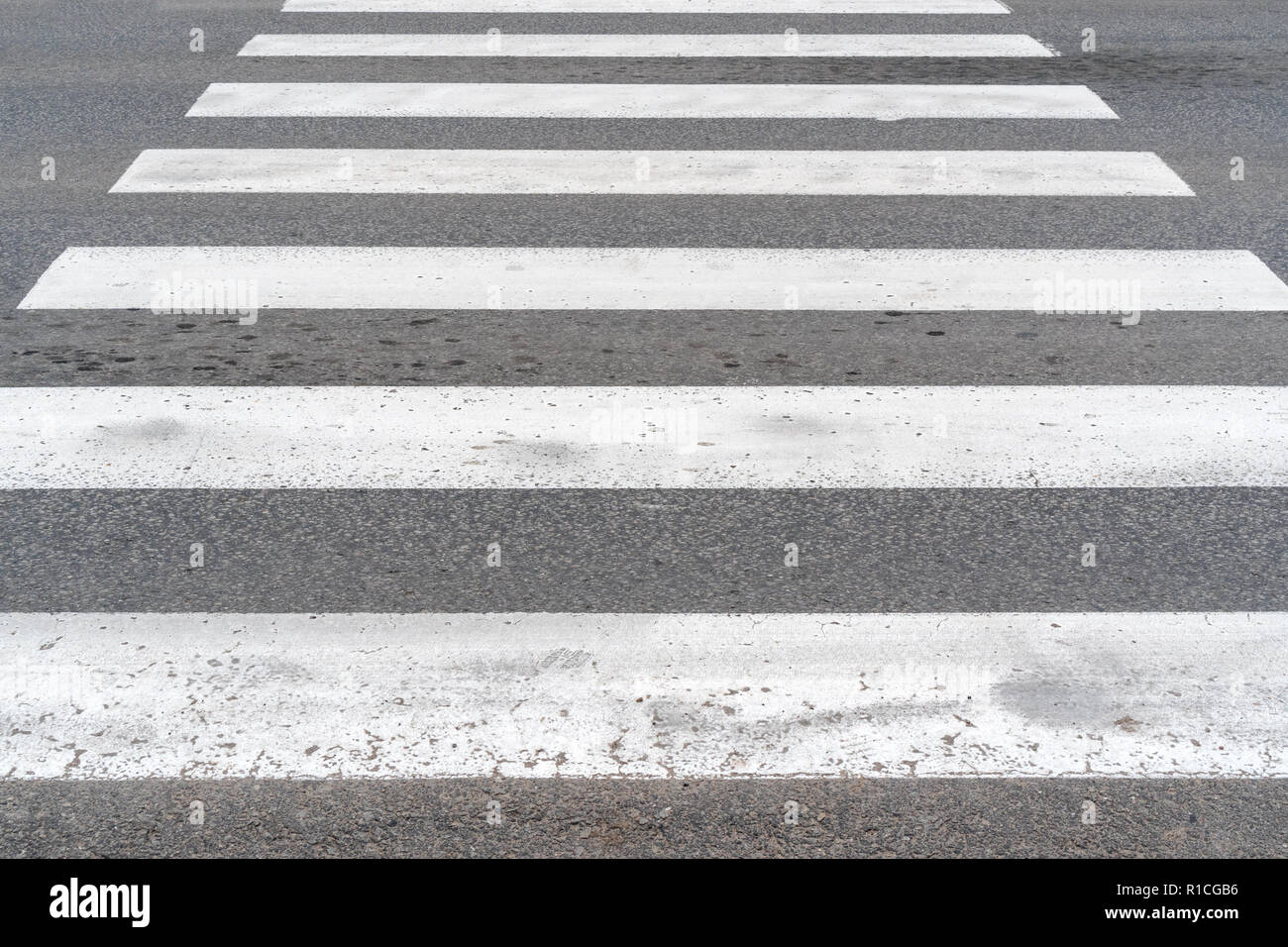 Crosswalk bianco su asfalto. La segnaletica stradale attraversamento pedonale di close-up. Foto Stock
