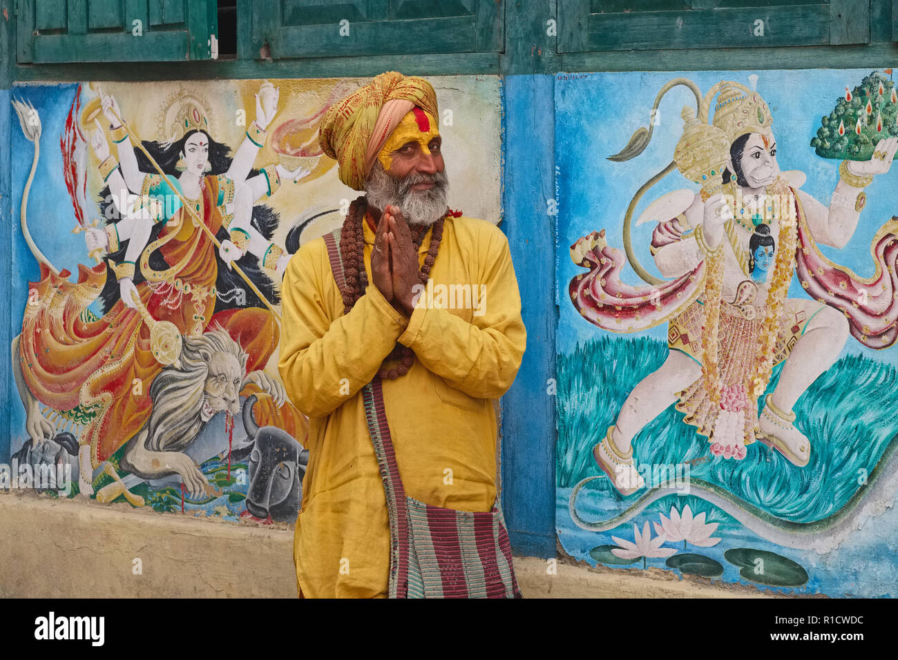 Un sadhu o uomo santo al tempio di Pashupatinath, Kathmandu, Nepal, catturati off-guard durante il suo tradizionale saluto di Namaste finalizzate al fotografo Foto Stock