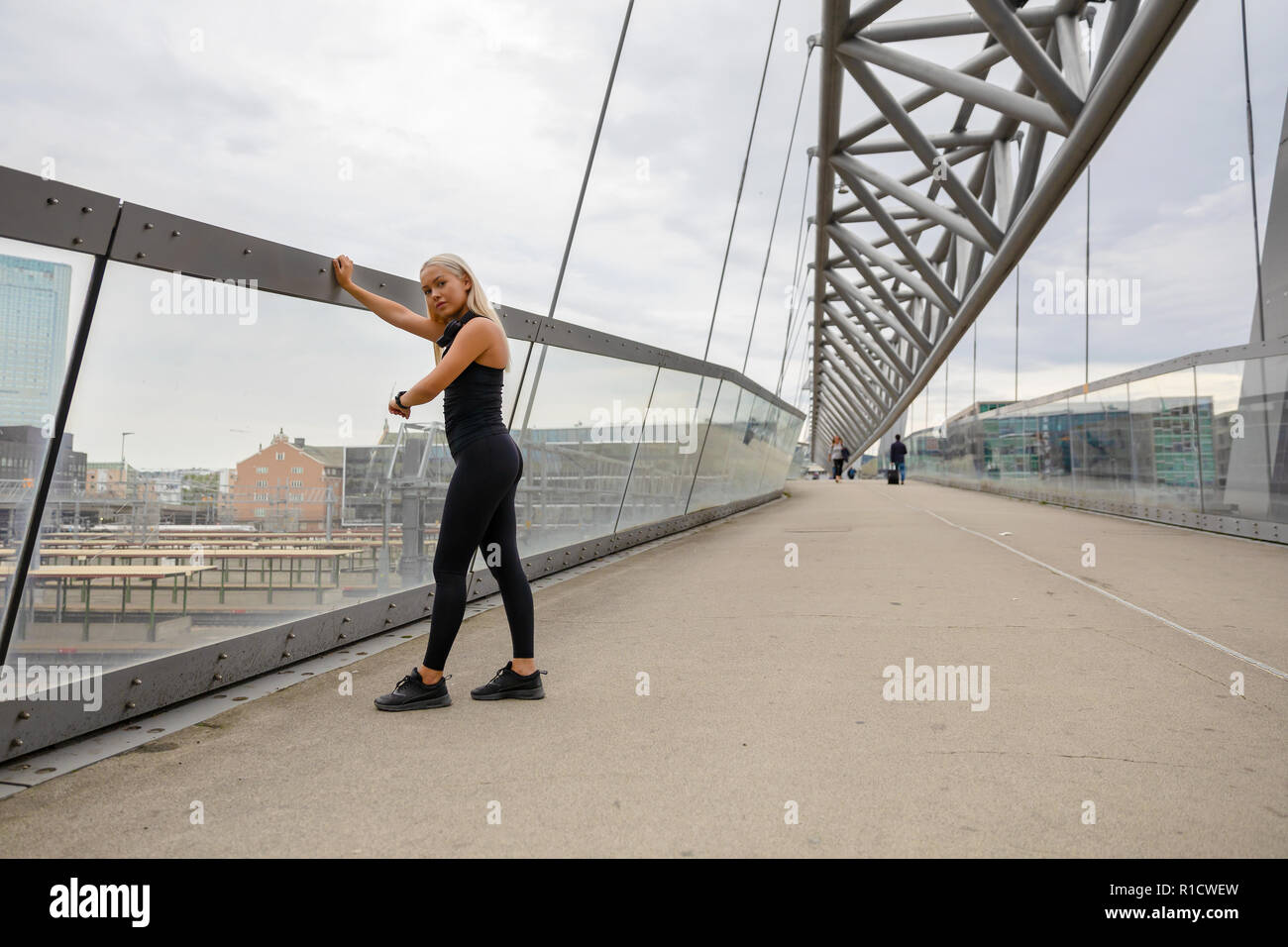 Donna controllando la frequenza cardiaca utilizzando Smartwatch dopo allenamento sul ponte Foto Stock