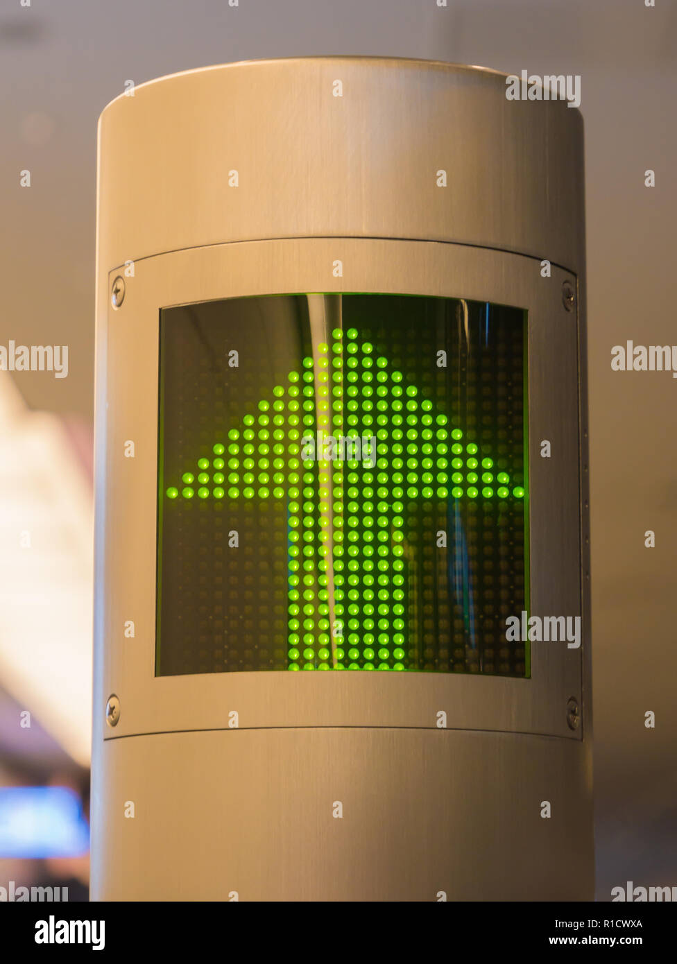 Illuminato verde segno di freccia che si dirige verso il passaggio che conduce al gate di partenza Foto Stock