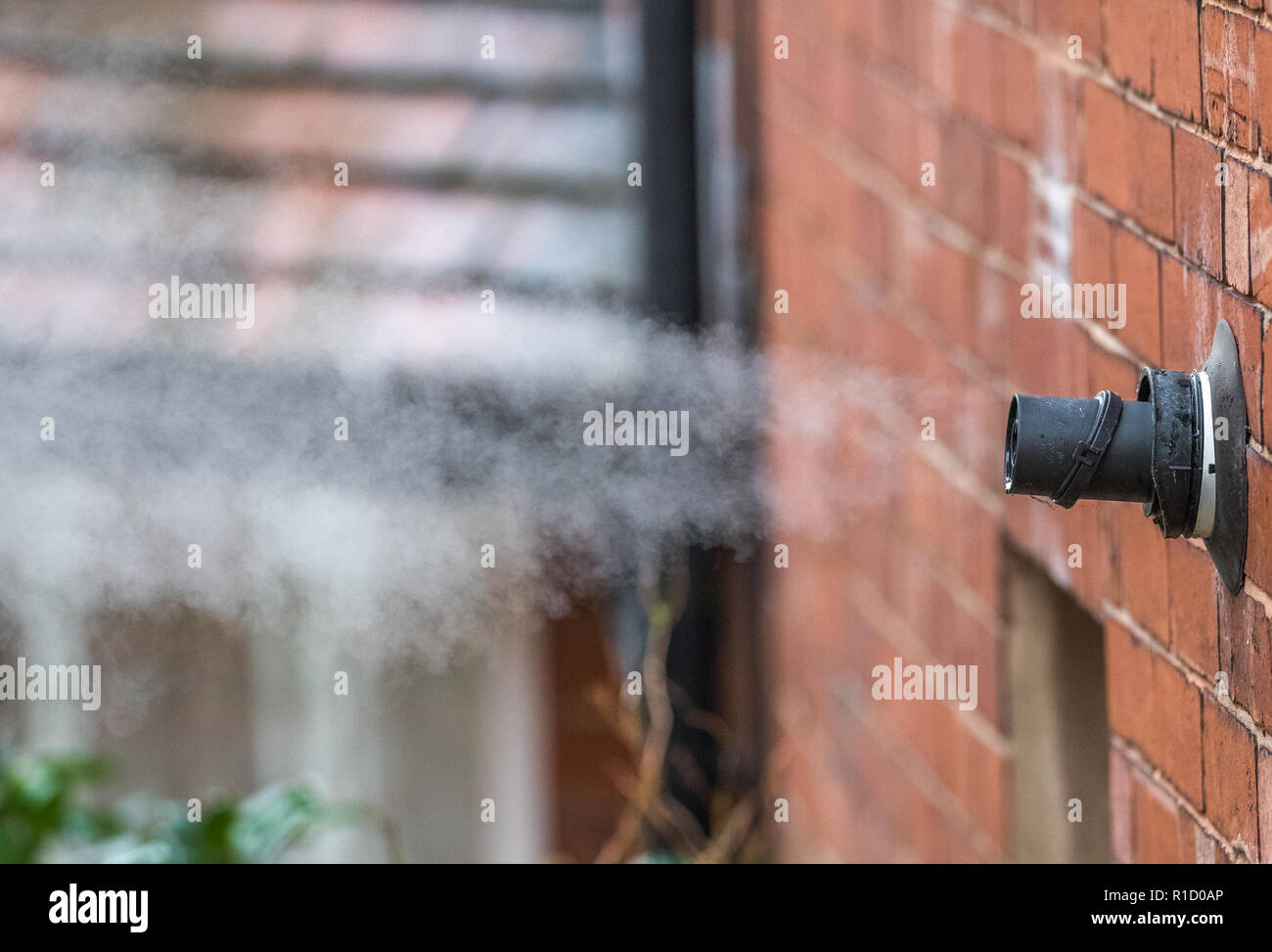 I fumi di scarico e il vapore acqueo proveniente da una combi caldaia gas attraverso la canna fumaria esterna tubo. Foto Stock