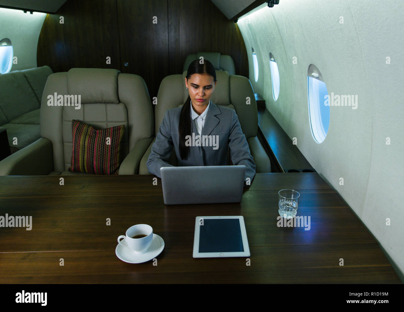 Imprenditrice a lavorare mentre viaggia su un jet privato - Ritratto di gente di affari prendendo un primo volo di classe per il lavoro, i concetti di business e Foto Stock
