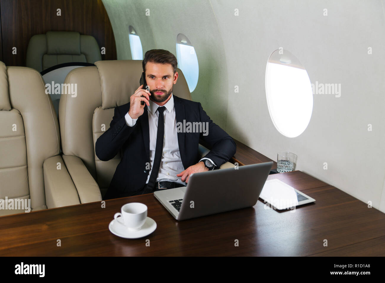 Imprenditore a lavorare mentre viaggia su un jet privato - Ritratto di gente di affari prendendo un primo volo di classe per il lavoro, i concetti di business e mo Foto Stock