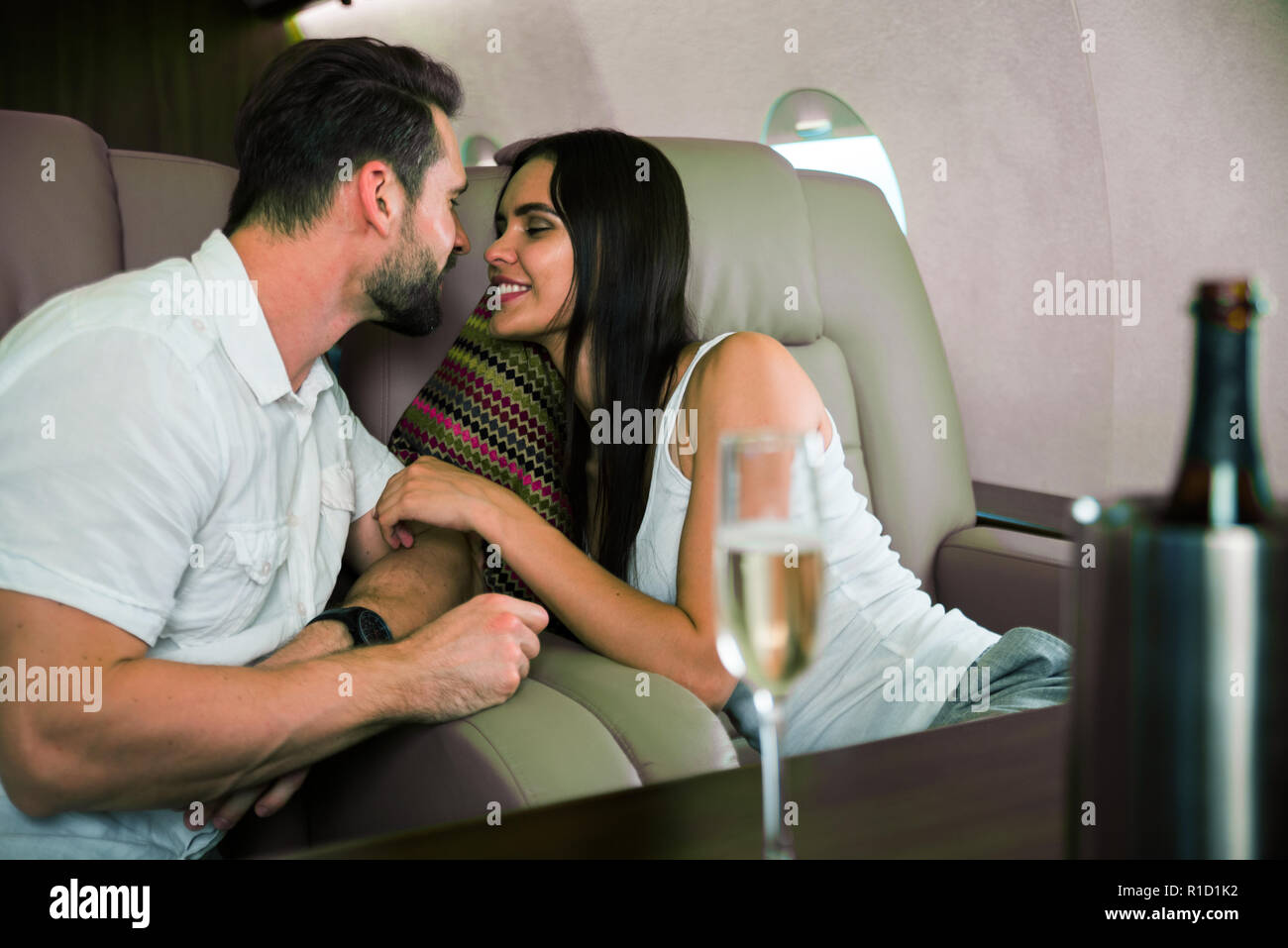 Coppia felice che viaggiano su un lusso jet privato - i giovani adulti viaggiano su un primo volo di classe, concetti sui viaggi e stile di vita Foto Stock