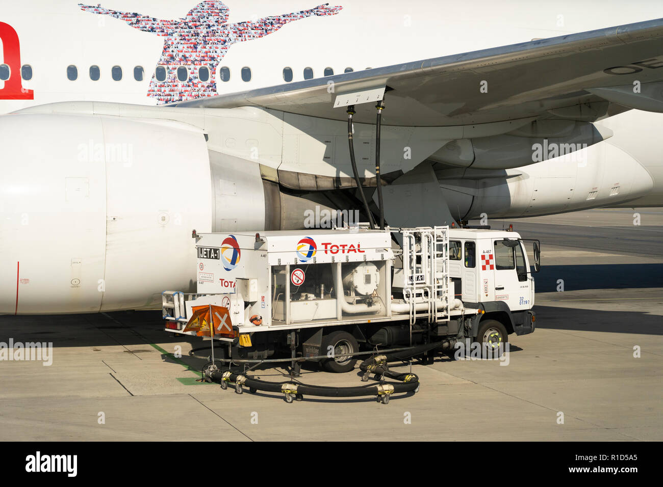 Un autocarro a carburante per aviazione totale che rifornisce un aereo di linea per passeggeri della Austrian Airlines all'aeroporto di Vienna, Austria Foto Stock