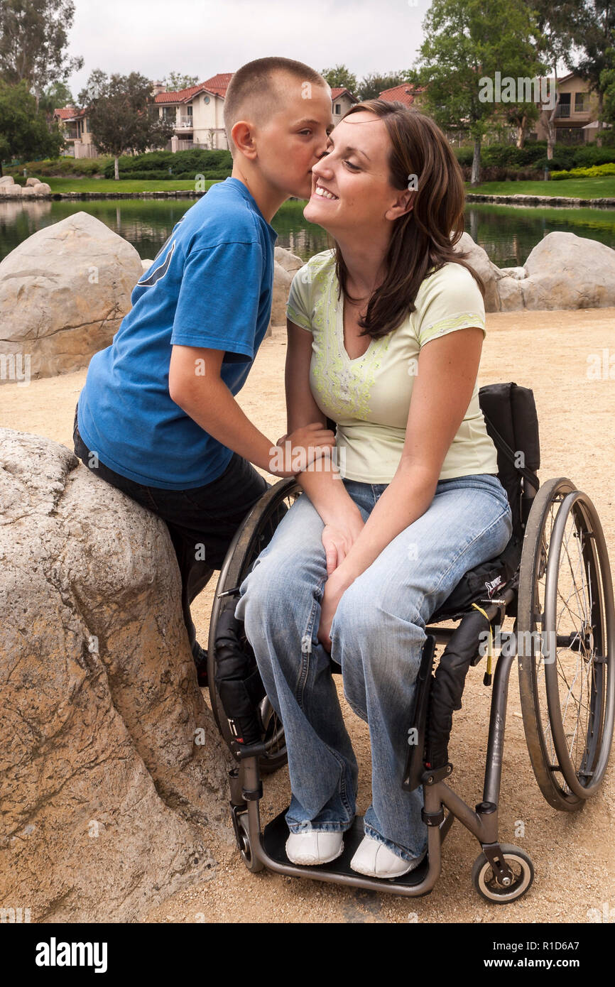 Figlio di baciare la guancia della madre disabili in carrozzella © Myrleen Pearson ...Ferguson Cate Foto Stock