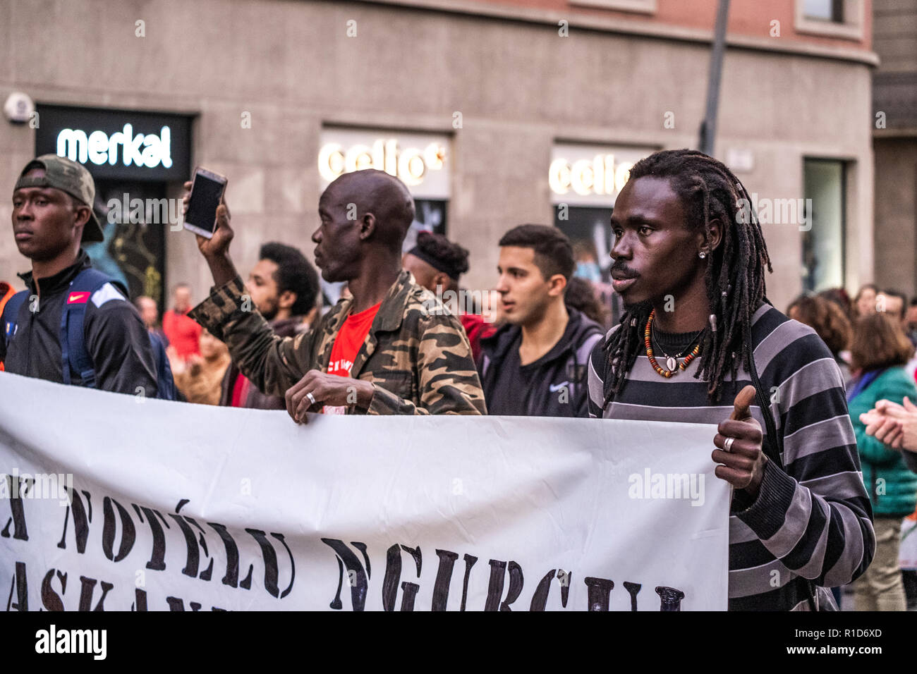 Diversi manifestanti nero sono visto dietro il banner durante la dimostrazione. Una nuova manifestazione contro il razzismo istituzionale ha attraversato le strade del centro di Barcellona. Accompagnata da organizzazioni sociali e il Sindacato dei venditori ambulanti, più di 500 persone hanno rivendicato per terminare il razzismo a Barcellona e hanno denunciato le identificazioni di polizia secondo il colore della loro pelle. Foto Stock