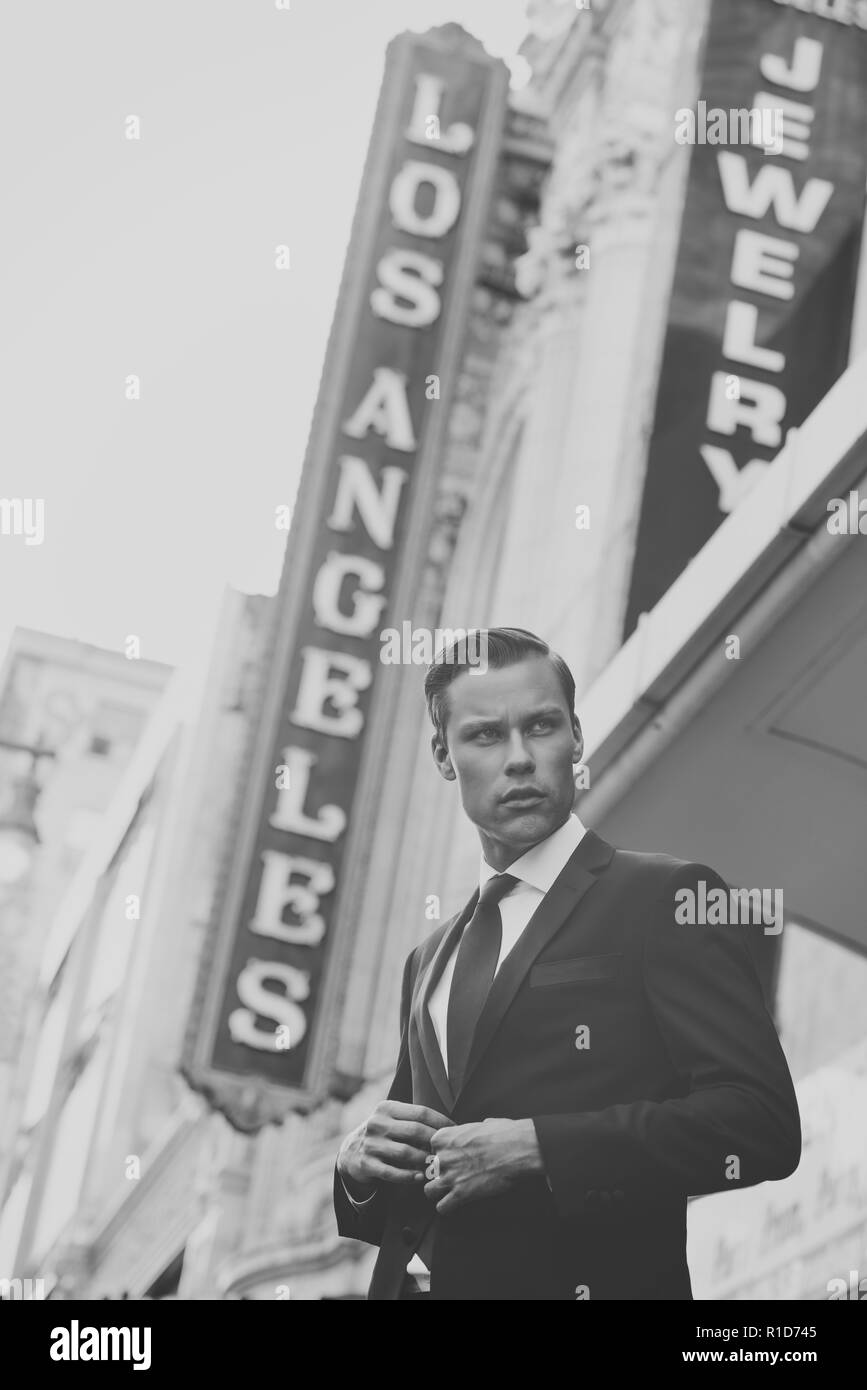 Un ritratto in bianco e nero di un modello maschile che guarda lontano con una Los Angeles segno dietro di lui. Un maschio ritratto vintage concetto. Foto Stock