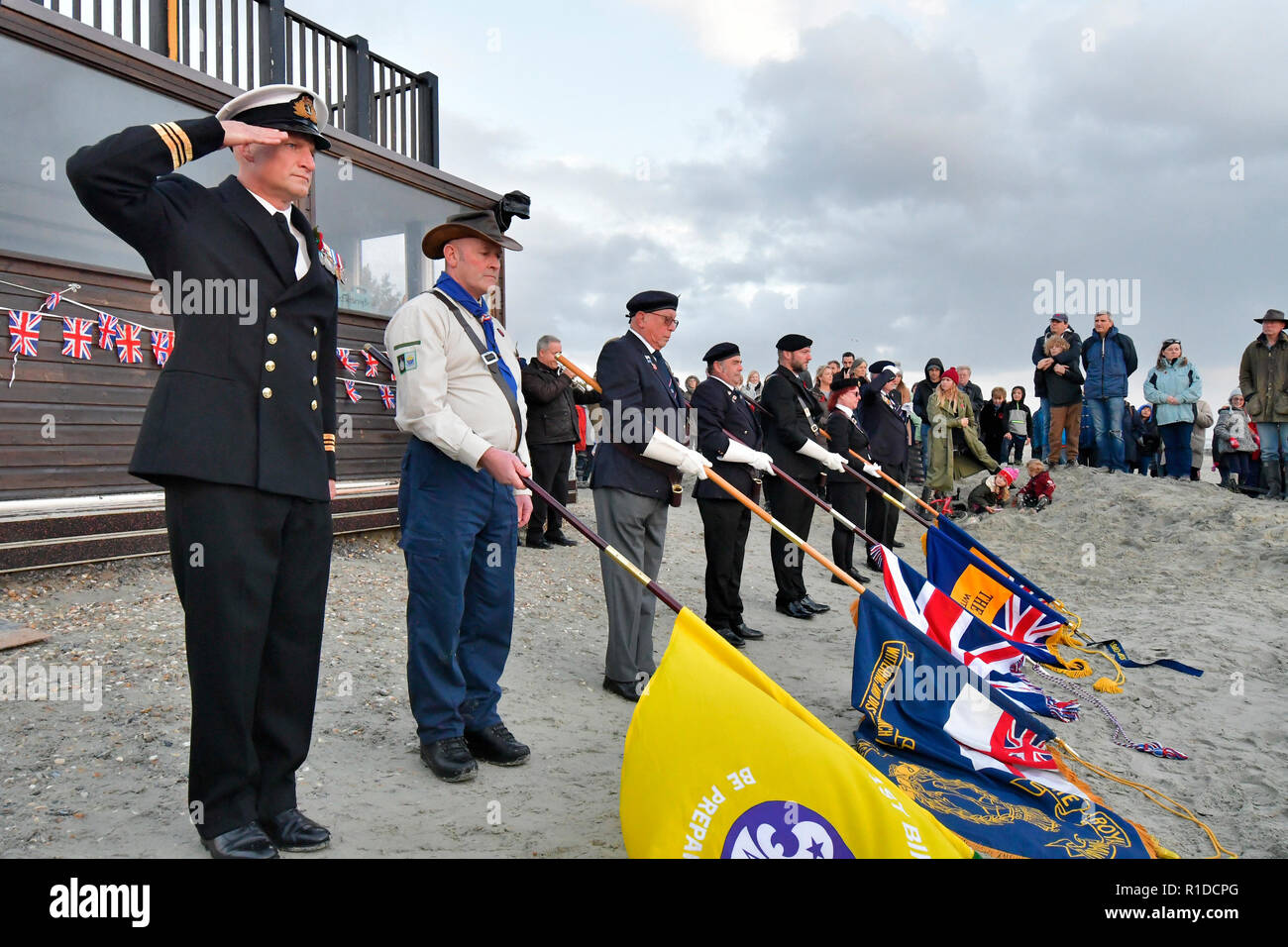 West Wittering Beach commemora il giorno dell'armistizio - la Legione Britannica reale di Wittering prende il saluto quando la tenuta di West Wittering ha invitato i residenti locali ed i visitatori ad unirsi a loro sulla spiaggia di Wittering per commemorare 100 anni dalla fine della prima guerra mondiale. Ispirato da "Pages in the Sea" di Danny Boyle Ð un evento artistico nazionale situato di fronte alla silhouette dello scultore locale Alexandra Beale nella sabbia di Charles Henry Kewell, uno dei quattro fratelli della famiglia Wittering Kewell occidentale uccisi in guerra.Contributor: Gary Blake / West Wittering Estate /Alamy Stock foto Foto Stock