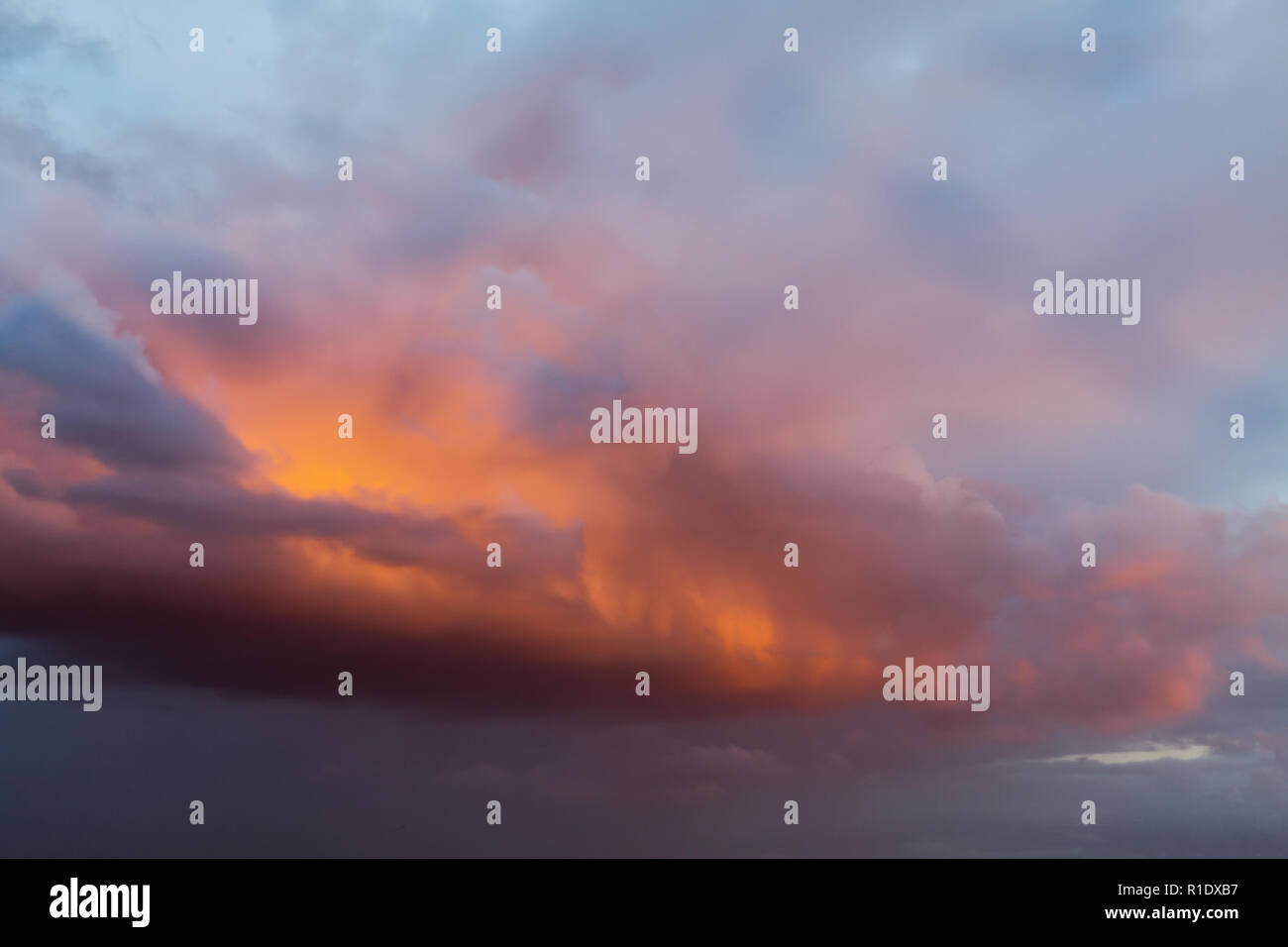 Bel colore arancione le nuvole e il cielo al tramonto con rosa e toni di viola Over England Regno Unito. Cloudscape e sfondo skyscape Foto Stock