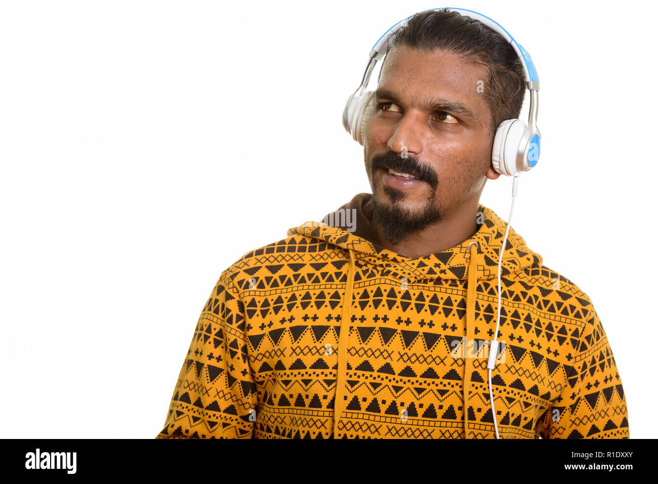 Giovani indiani felici uomo pensare mentre si ascolta la musica Foto Stock