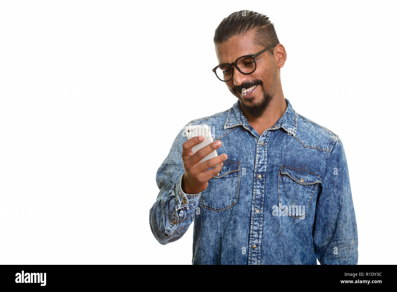 Giovani indiani felice l'uomo utilizzando il telefono cellulare Foto Stock