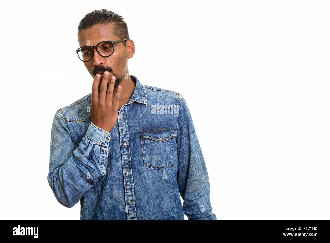 Giovani indiani man looking colpevole ritratto in studio contro uno sfondo bianco Foto Stock