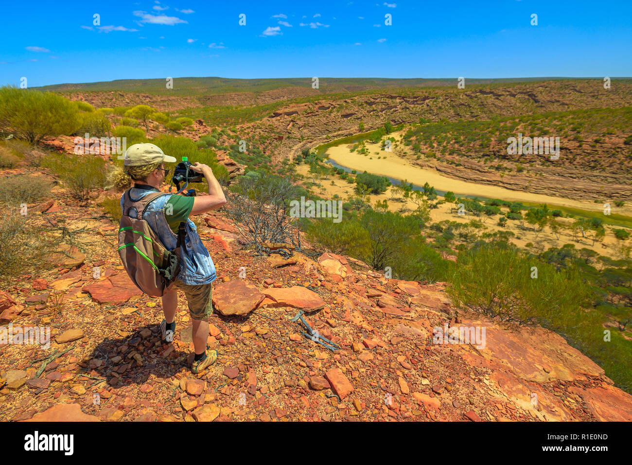 Fotografo di viaggio zaino in spalla con lo stabilizzatore ha girato a Murchison River Gorge in Kalbarri National Park, Australia occidentale. Videomaker professionale con fotocamera scatta foto in outback australiano. Foto Stock