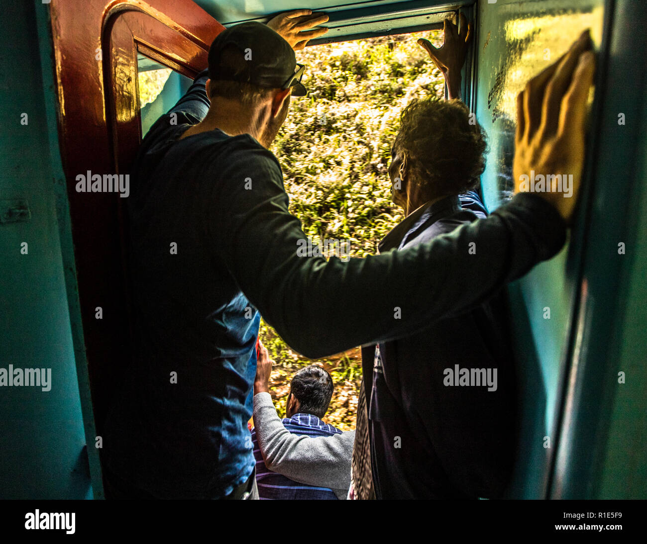 Treno espresso in Sri Lanka. Sia che siate seduti sui gradini o in piedi, i posti a sedere alle porte sono molto richiesti - anche tra la gente del posto Foto Stock