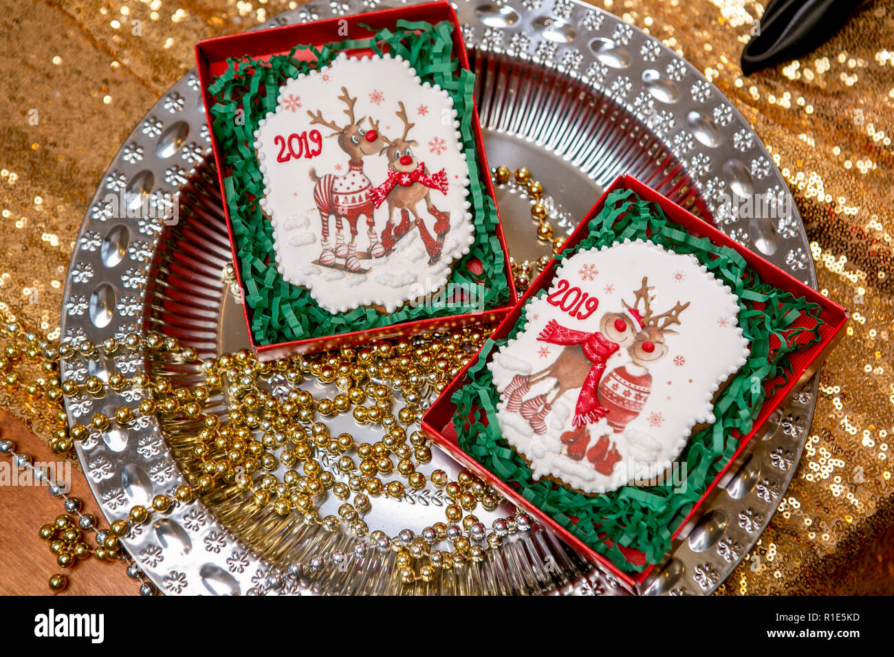 Cookie con caprioli e numeri 2019 in scatola di cartone su un vassoio con i talloni su sfondo dorato. Holiday dolci. Nuovo anno e tema natalizio. Festive mo Foto Stock