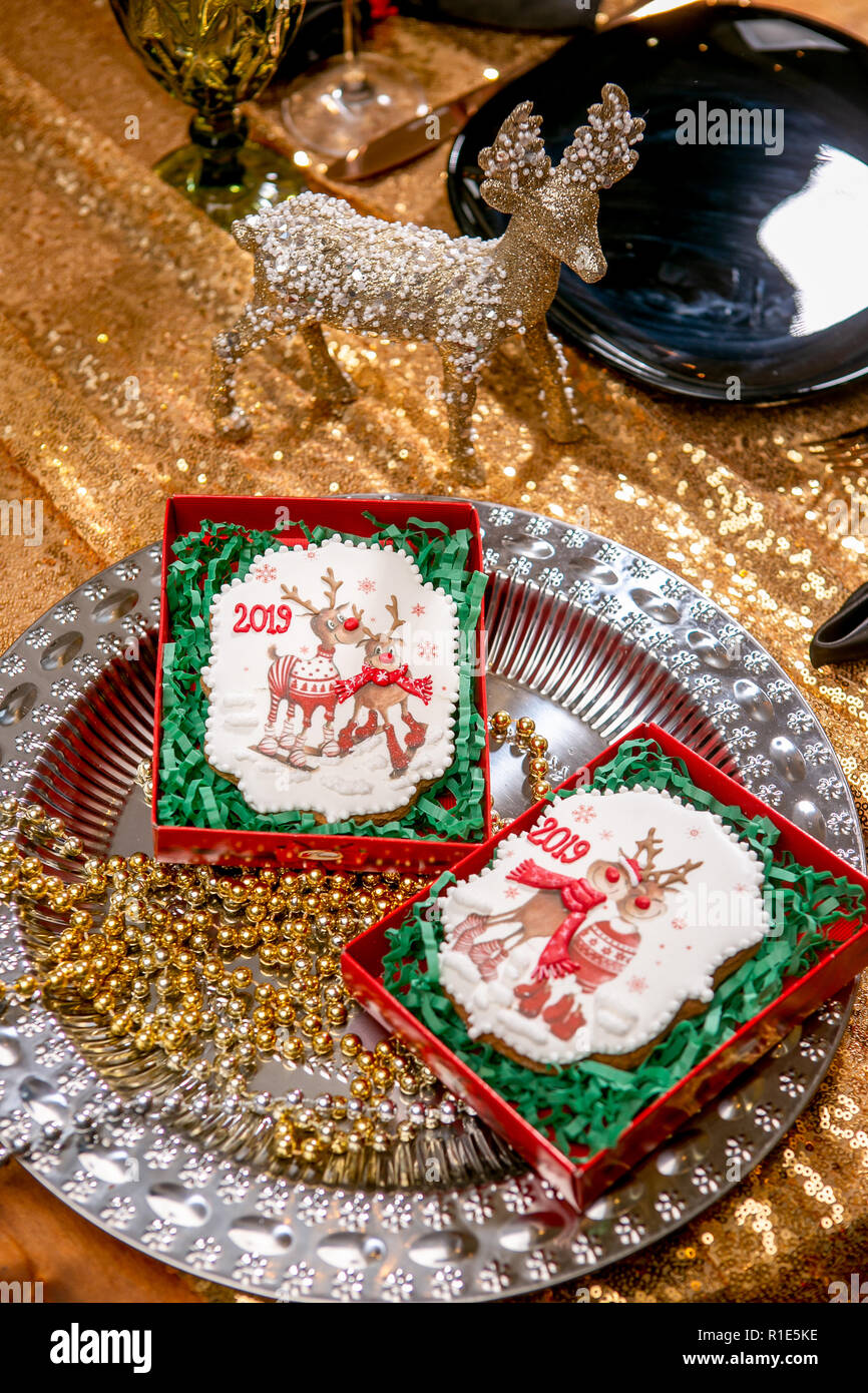 Cookie con caprioli e numeri 2019 in scatola di cartone su un vassoio con i talloni su sfondo dorato. Holiday dolci. Nuovo anno e tema natalizio. Festive mo Foto Stock