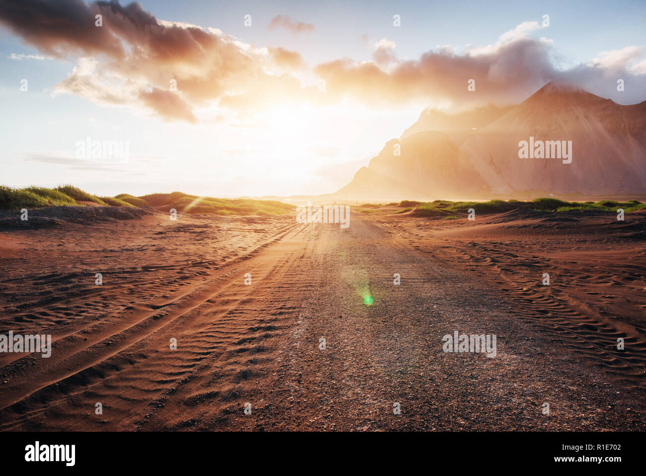 Fantastico tramonto sulle montagne e lava vulcanica dune di sabbia della spiaggia di Stokksness. Il concetto di una giornata calda e un deserto Foto Stock