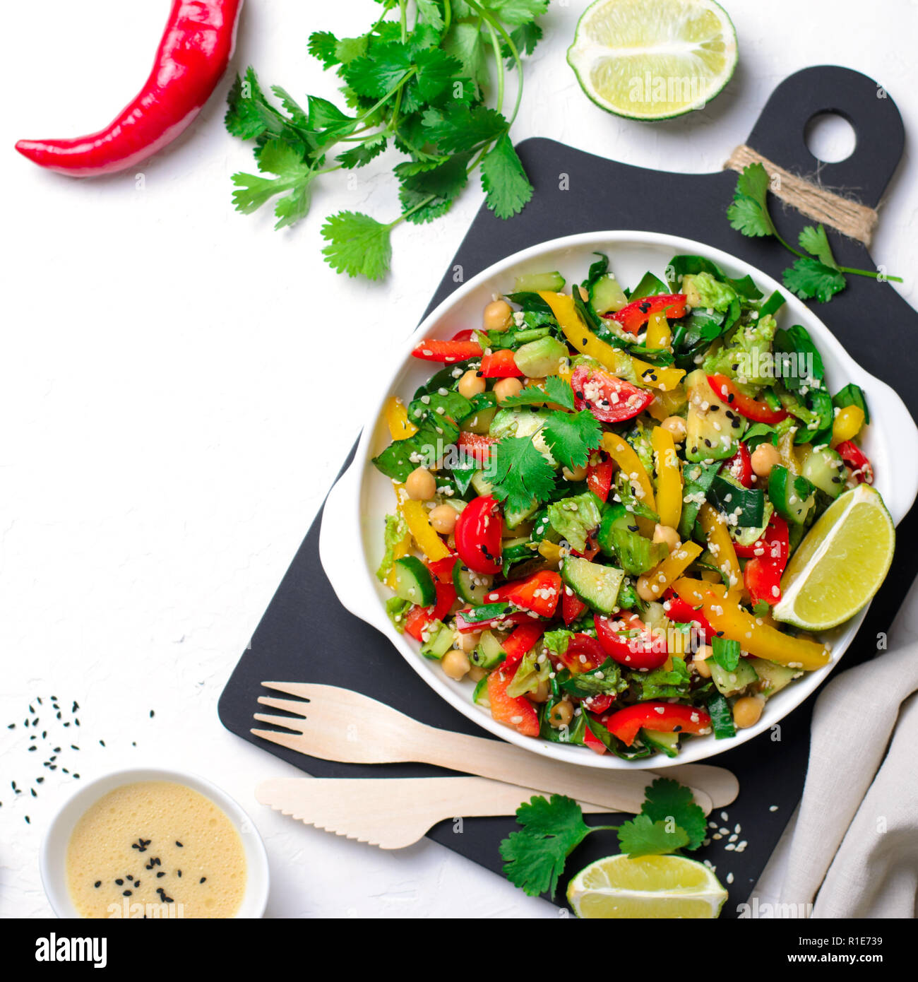 Fresca insalata di verdure, sano pasto vegano con Avocado, ceci, peperone, cetriolo, spinaci e tahini vestirsi, mangiare sano Foto Stock