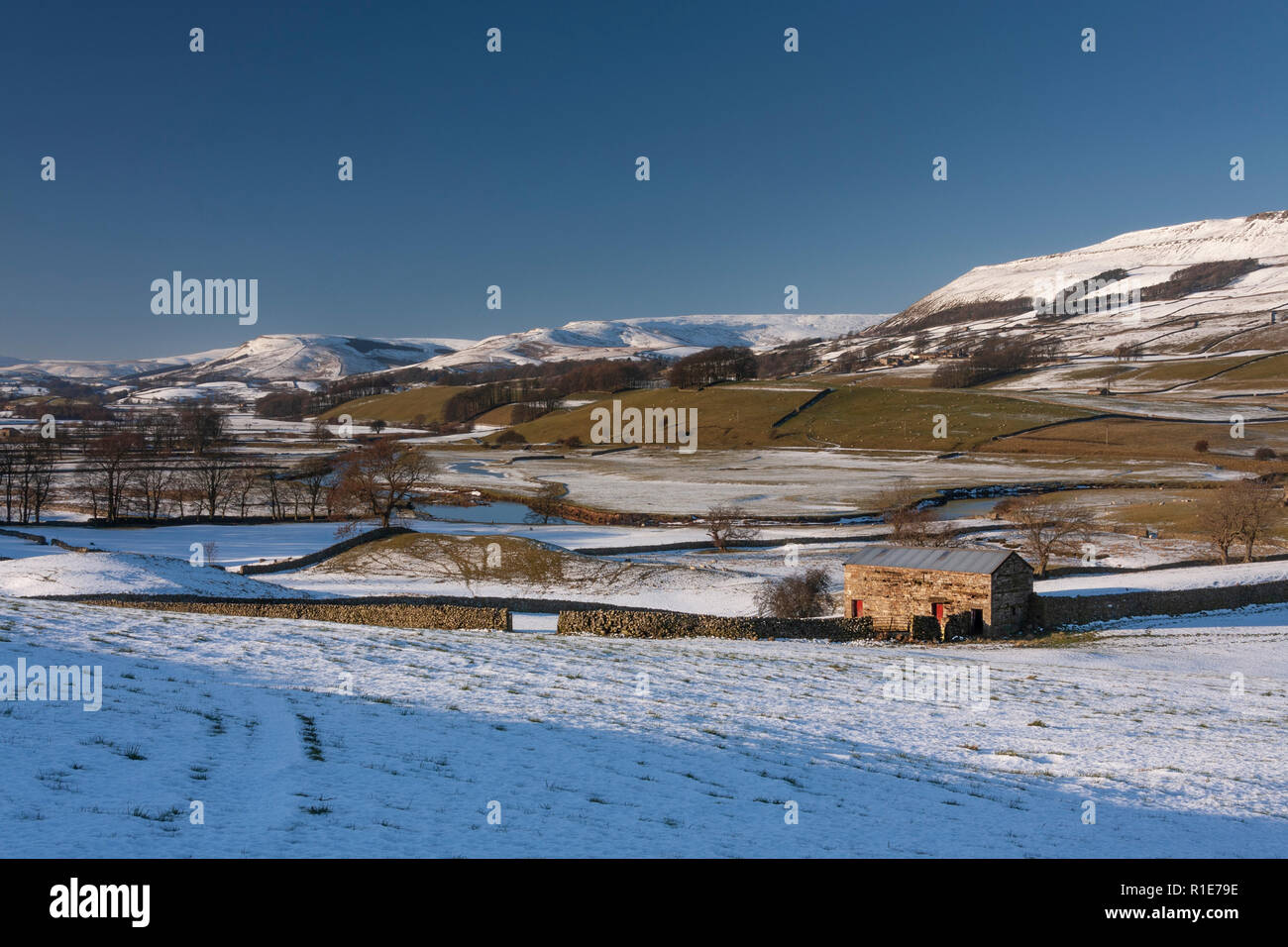 La neve sulle colline sopra i falchi, framing granaio e pecore. Wensleydale nel Yorkshire Dales. North Yorkshire Foto Stock