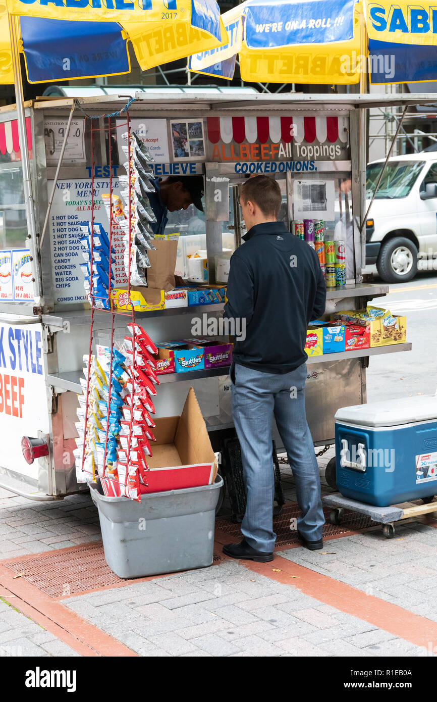 CHARLOTTE, NC, Stati Uniti d'America-10/30/18: un uomo mette in atto un ordine a un piccolo carrello alimentare su Tryon Street in uptown. Foto Stock