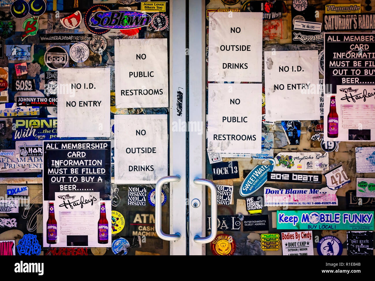 Segni e adesivi per lettiera la porta di un bar su Dauphin Street, nov. 3, 2018 in Mobile, Alabama. Foto Stock