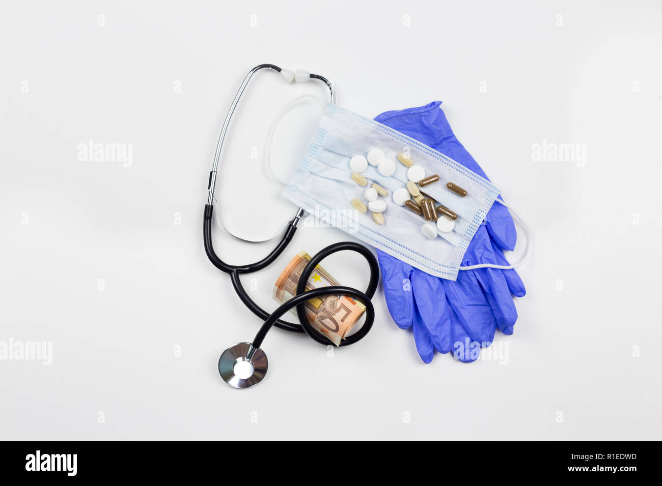 Donazioni nel settore sanitario concetto. Denaro con strumenti medicali isolato su bianco. Foto Stock