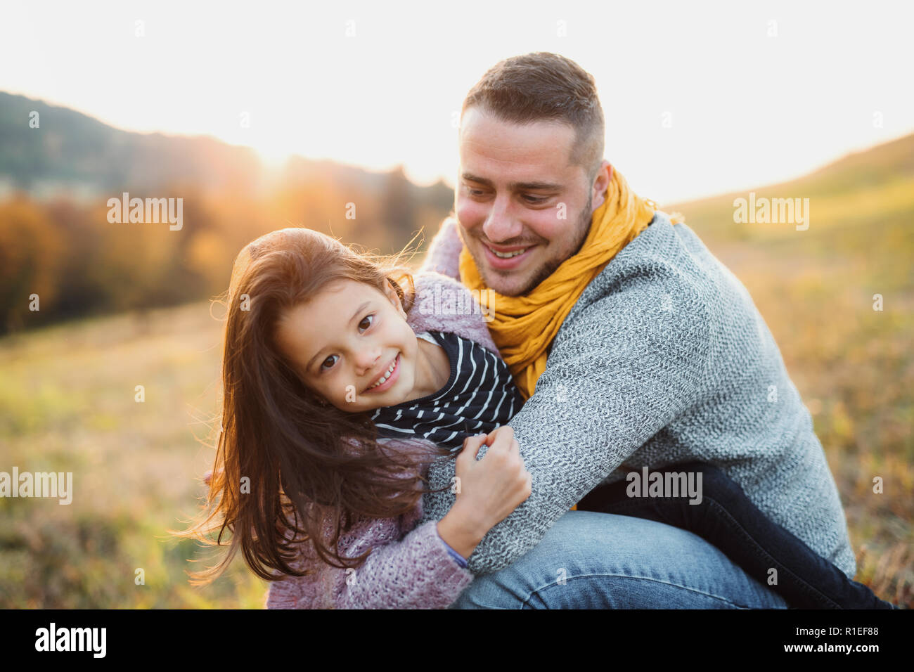 Un giovane padre avendo divertimento con una piccola figlia in autunno la natura. Foto Stock