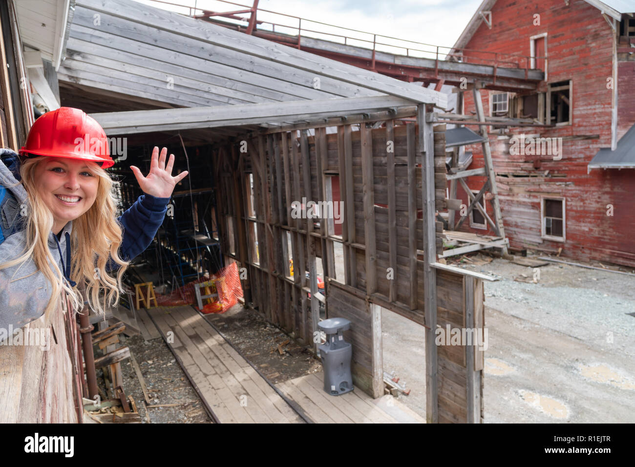 I giovani adulti donna che indossa un elmetto onde attraverso un vetro rotto durante un tour della miniera Kennecott in McCarthy Alaska Foto Stock