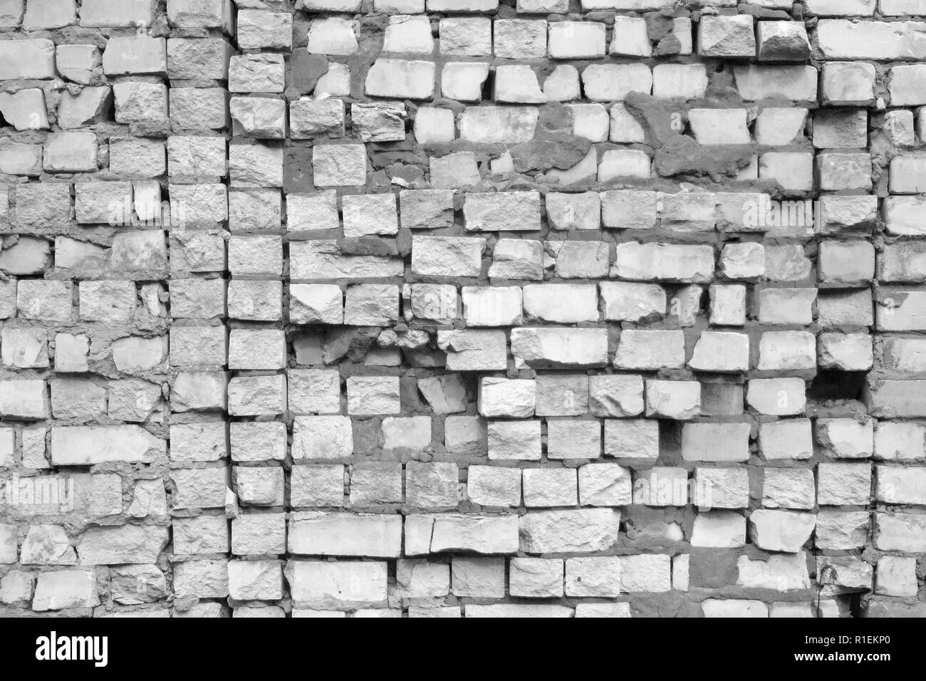 Si è schiantato muro in mattoni texture. Vecchio di età compresa tra i mattoni rotti sfondo. Demolizione della casa Foto Stock