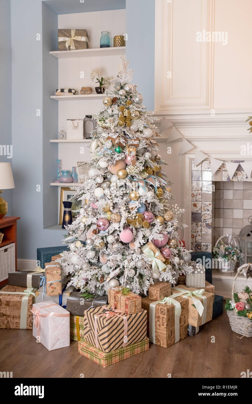 Interno soggiorno con un albero di Natale e decorazioni.bella vacanza sala  decorata con albero di Natale con presenta sotto di esso.Anno nuovo interno  con un abete bianco ,toni pastello Foto stock -