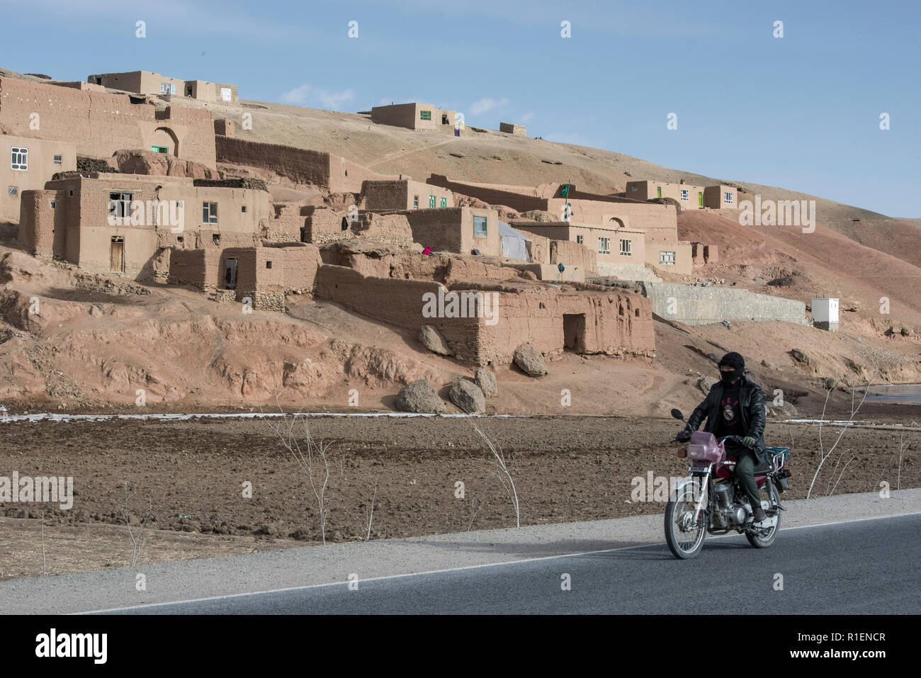 Abitante del motociclo di guida su strada asfaltata da Bamyan di band-e Amir National Park, nella provincia di Mazar-i-Sharif, Afghanistan Foto Stock