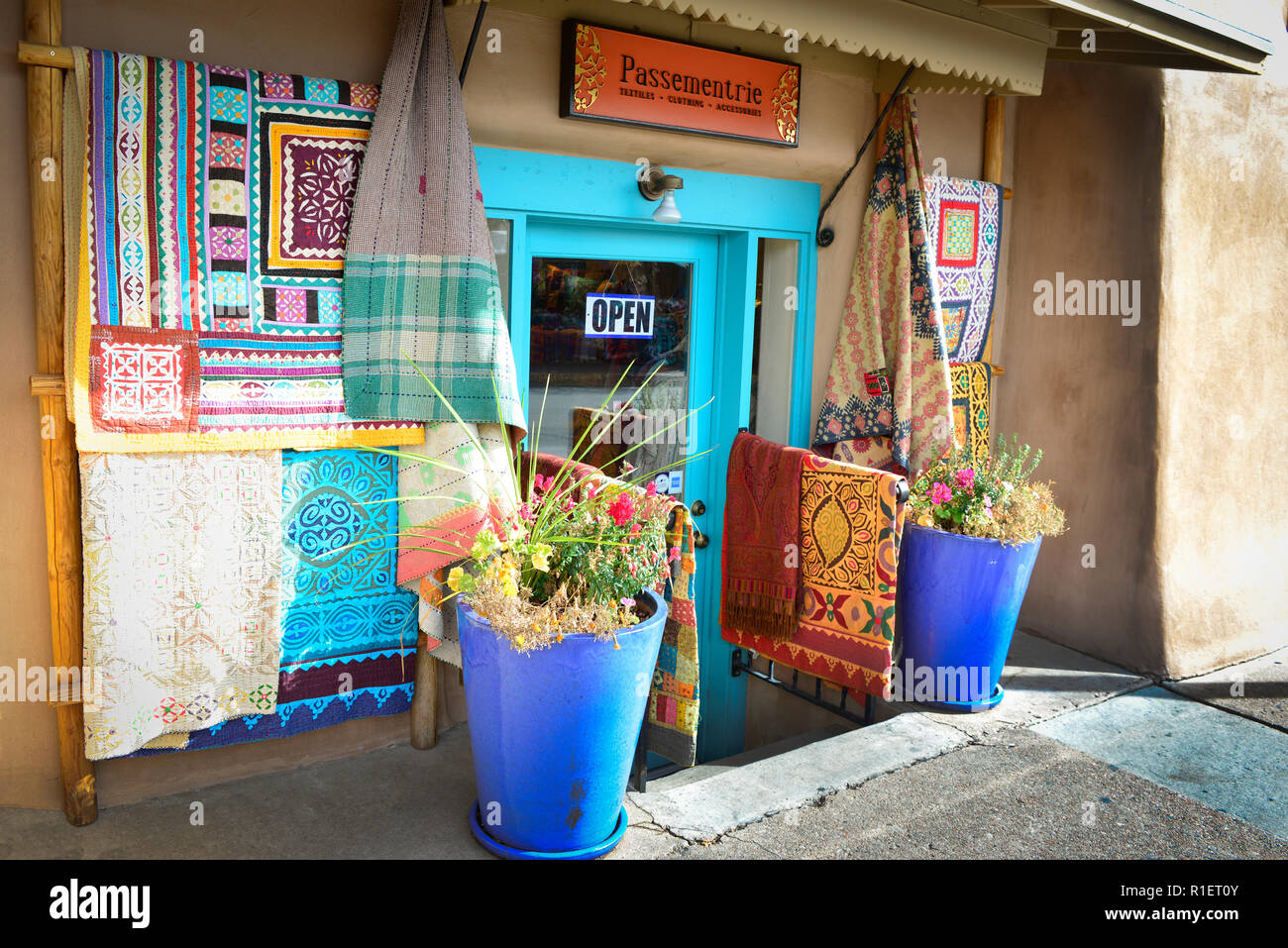 Un negozio di tessuti che espongono la loro mercanzia colorata al di fuori del loro ingresso nel centro storico di Santa Fe, NM Foto Stock