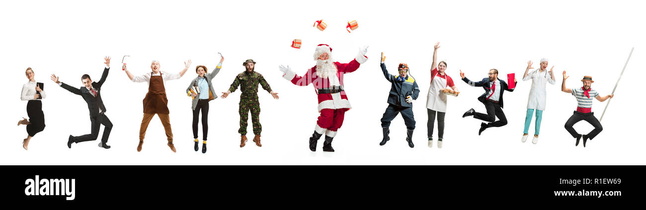 Collage di diverse professioni. Un gruppo di uomini e donne in uniforme jumping in studio con Santa isolato su bianco. A lunghezza piena di persone con diverse professioni. Il Natale e il concetto di vacanza Foto Stock