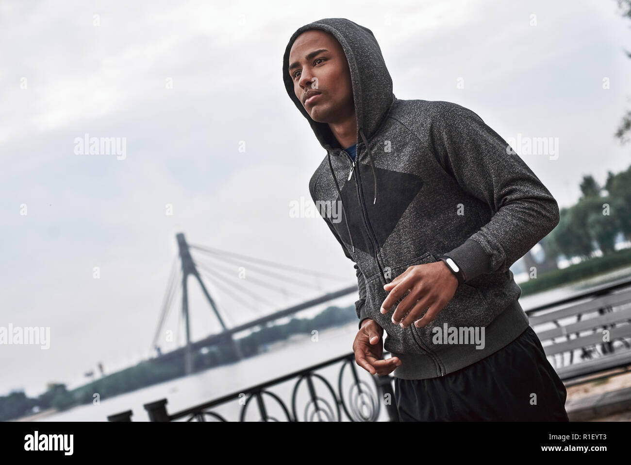 Mattina in esecuzione. Chiusura del giovane africano jogging sul parco all'aperto Foto Stock