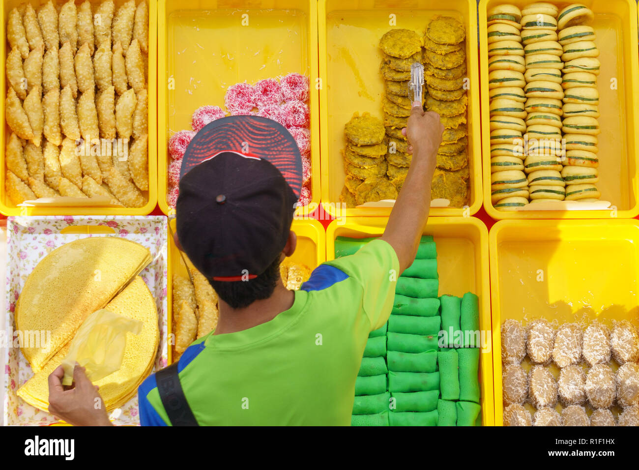 Varietà di gustosi e colorati casa malese cucinato dolci locali o 'kueh' venduta al mercato di strada stallo in Kota Kinabalu Sabah dall'alto angolo di visione w Foto Stock