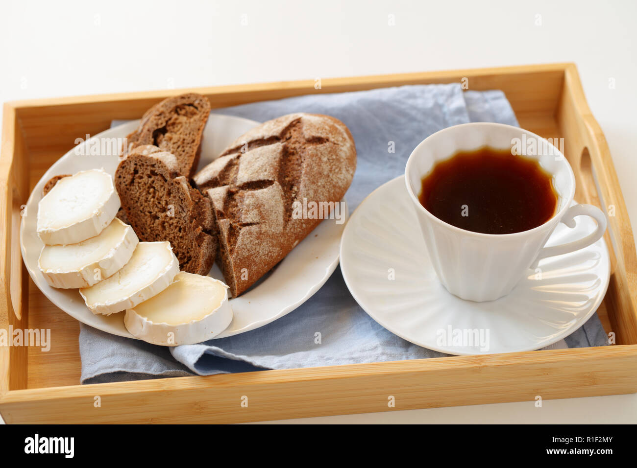 La prima colazione con formaggio di capra, pane di segale e caffè su un vassoio Foto Stock