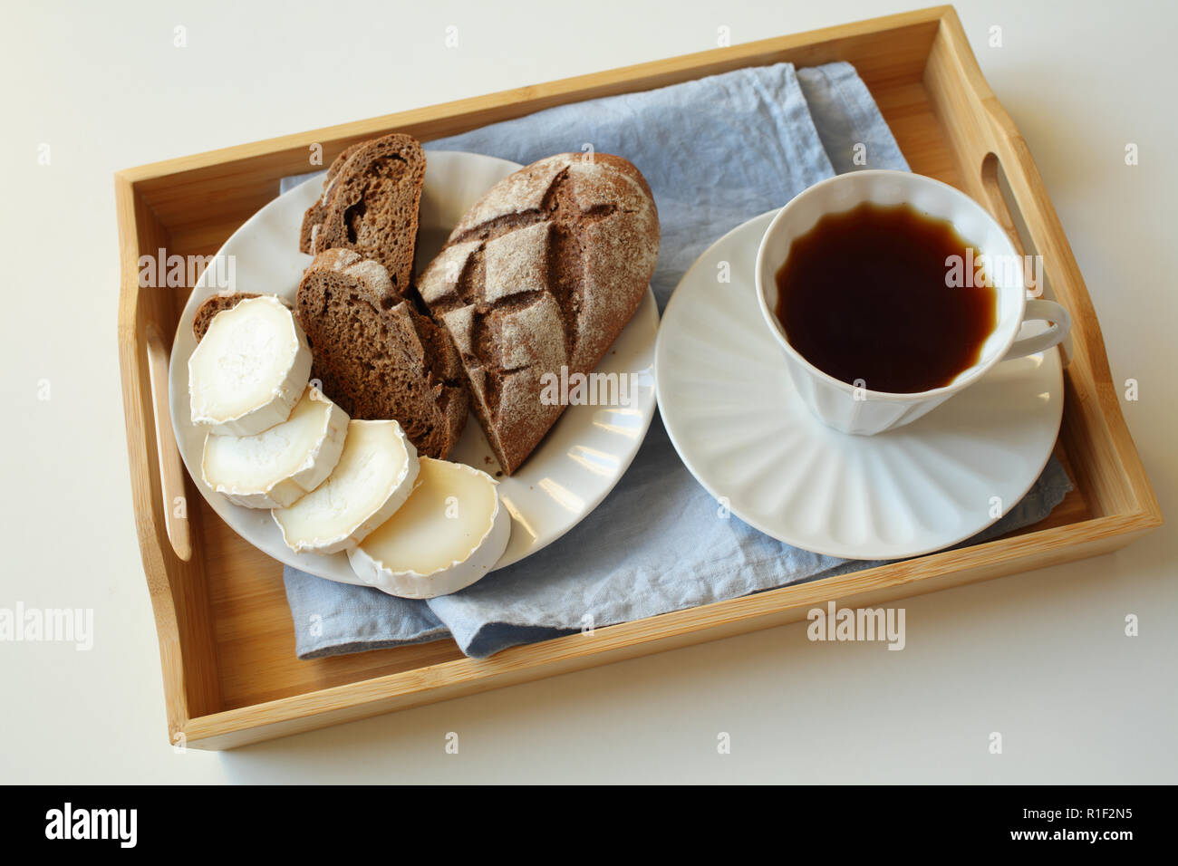 La prima colazione con formaggio di capra, pane di segale e caffè su un vassoio Foto Stock