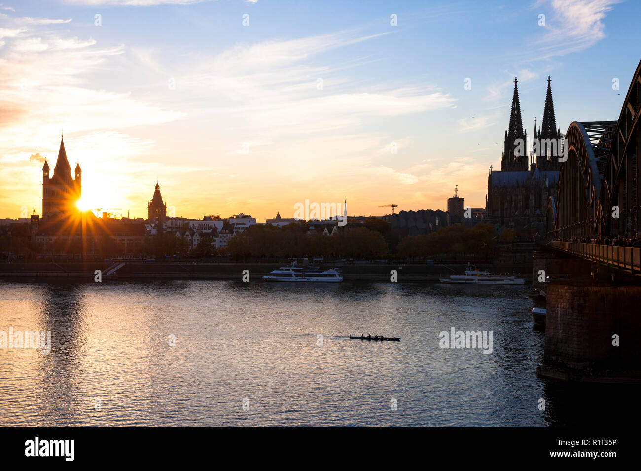 Il fiume Reno e dalla parte vecchia della città con la chiesa romanica lordi di San Martino, la cattedrale e il ponte di Hohenzollern, tramonto, Colonia, Foto Stock