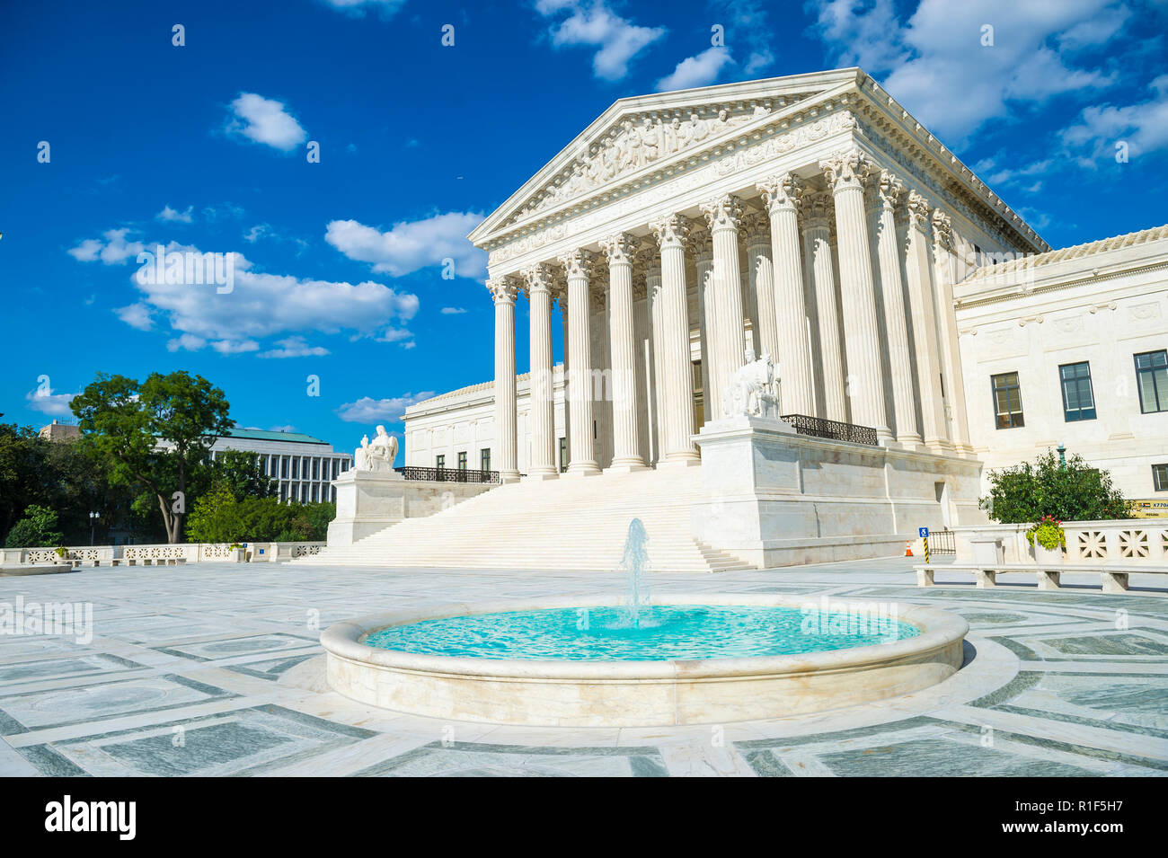 Luminoso vista panoramica del neo-classica facciata della Corte suprema degli Stati Uniti edificio dal plaza fontana sotto il cielo blu Foto Stock