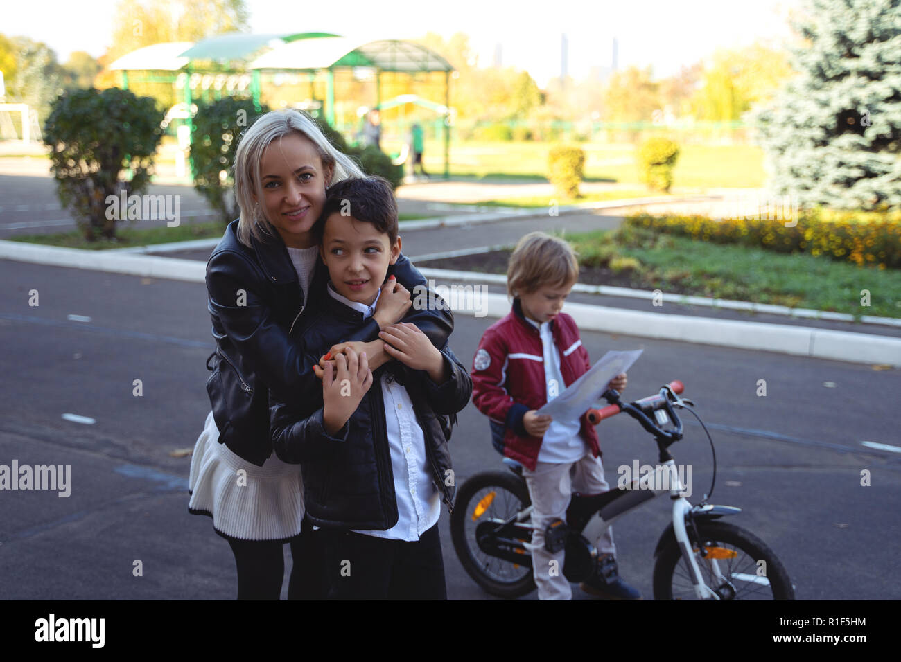Felice madre e figlio di soffiaggio bolle di sapone su strada Foto Stock