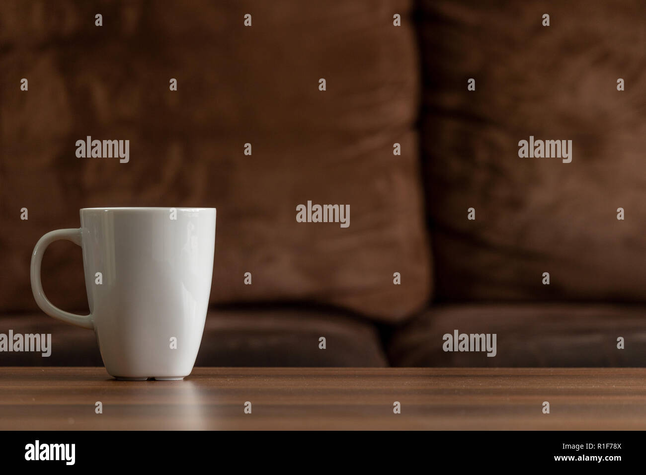 Tazza bianca su una tavola di legno con un lettino marrone background. copia spazio lasciato oltre per testo e immagini Foto Stock