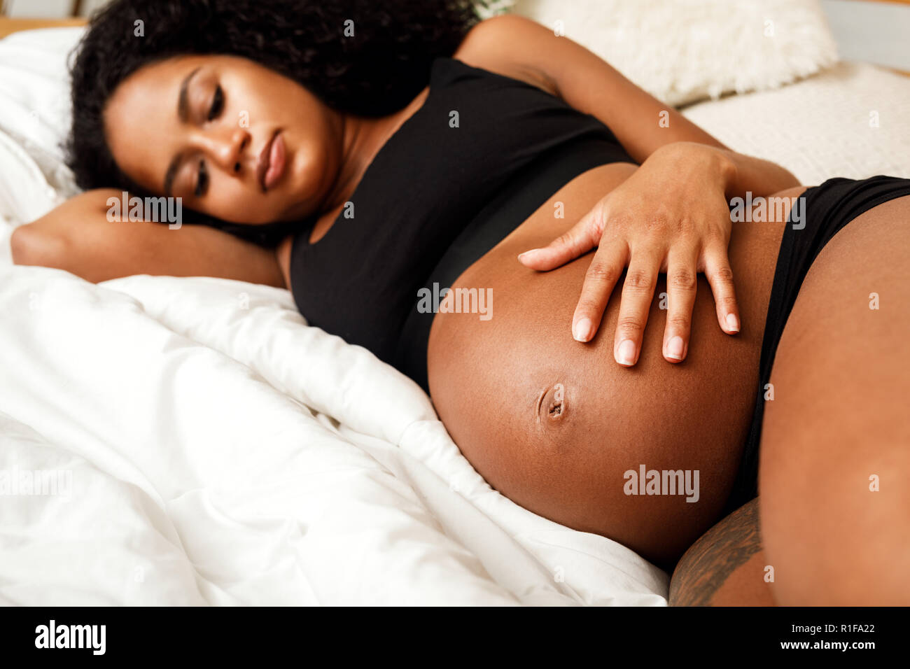 Close up della donna incinta toccando il suo ventre Foto Stock