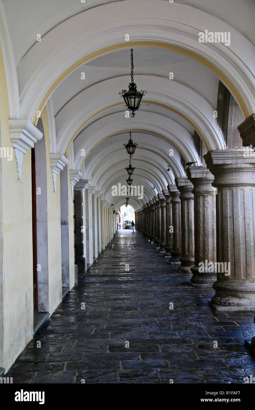 Un romantico giallo pallido e bianco elegante passerella arcuata con appendere le lampade in metallo Foto Stock